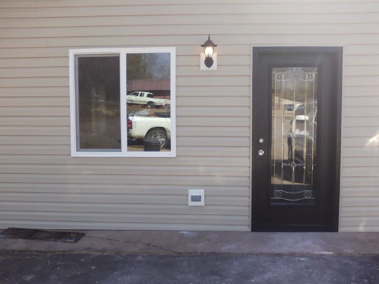 New siding, window and entry door on the side of an addition in Taylor Ridge