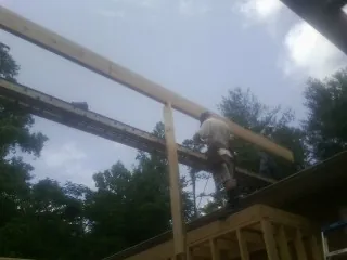 Carpenter setting a ridge beam over a new addition frame — Ice Dam Removal by Roofing Brothers in Taylor Ridge