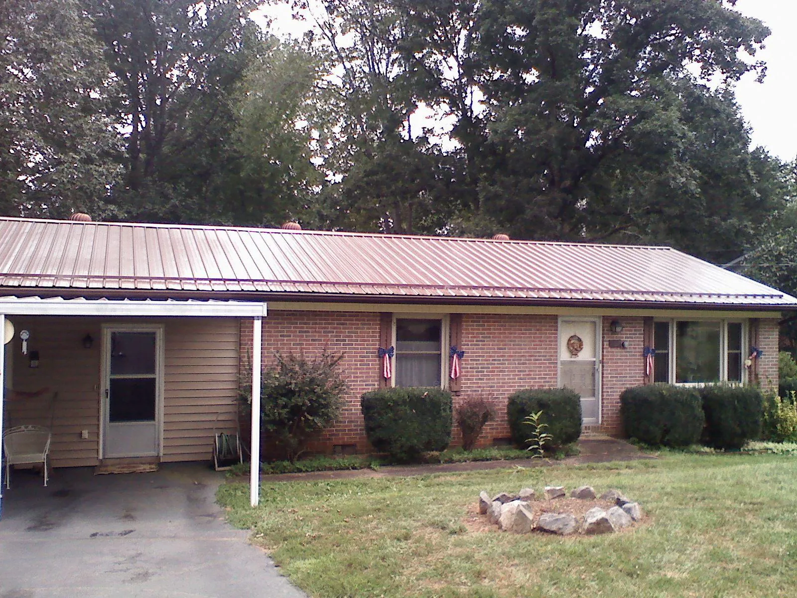 Bronze metal roof and carport on a brick ranch home — Roof Repair work by our crew in Taylor Ridge